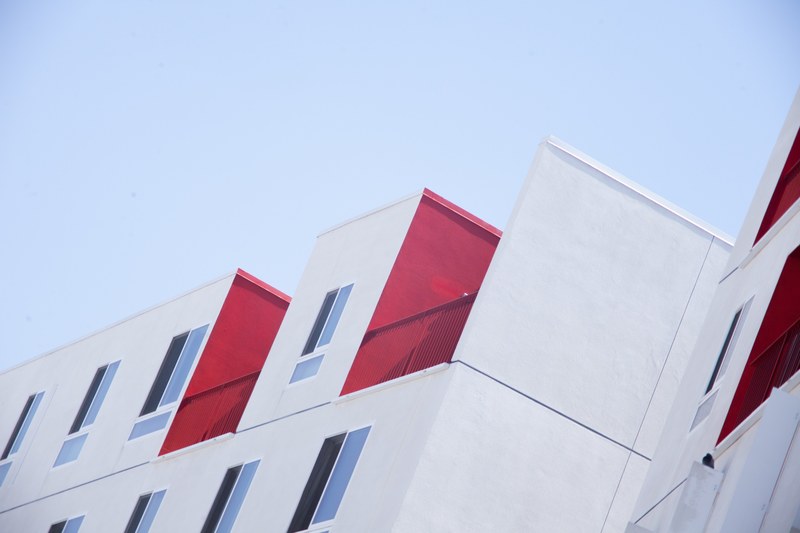 a white residential building facade with red balconies in los angeles, white and red building 4k