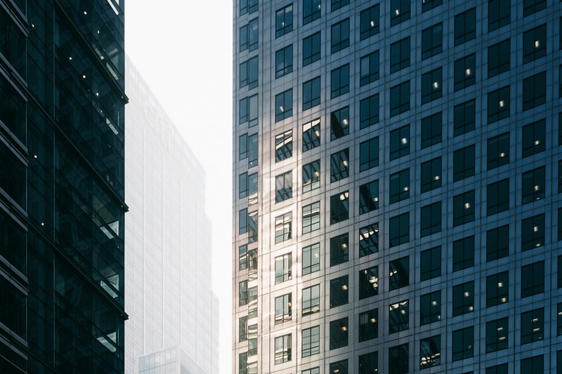 sun shining on the facade of a tall building in canary wharf london, light on skyscraper windows 4k