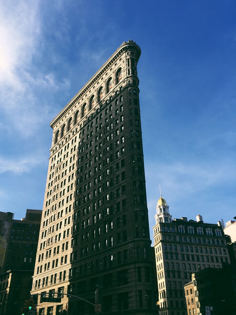 flatiron building in new york with cloudy blue sky and building shadow on windows, flatiron window shadow 4k