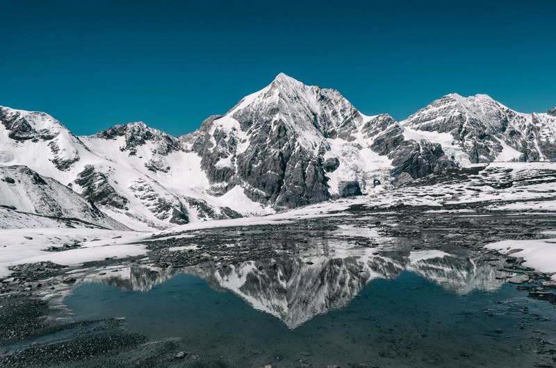 snowy peaks of ortler reflected in the icy water, reflected mountains at ortler 4k