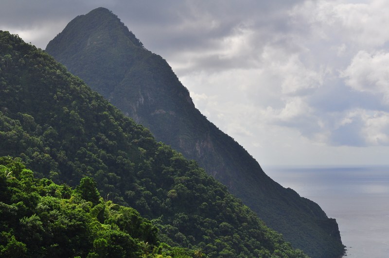 a tall wooded mountain peak at the seashore, mountain by the sea 4k