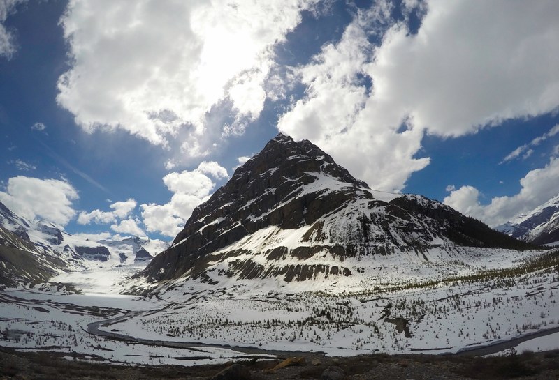 fluffy clouds flit past the snowy rocky valley of mount robson, clouds across mount robson valley 4k