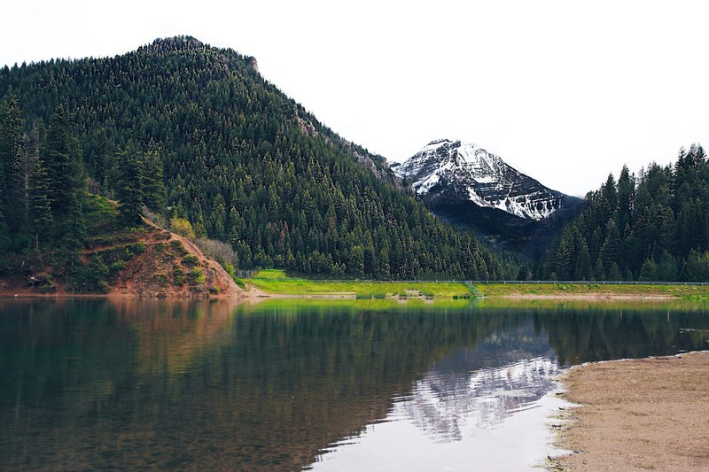 a snowy mountain reflected in a lake, lake near a wintry mountain 4k