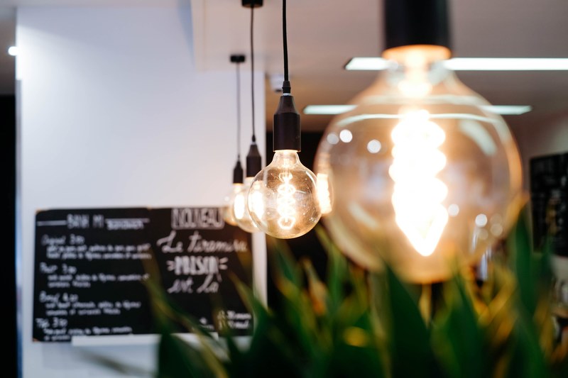 hanging vintage style lightbulbs glowing inside of a restaurant, glowing light bulbs in restaurant 4k