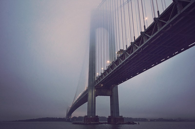city bridge with streetlights sits over still waters on a misty eventing, city bridge at dusk 4k