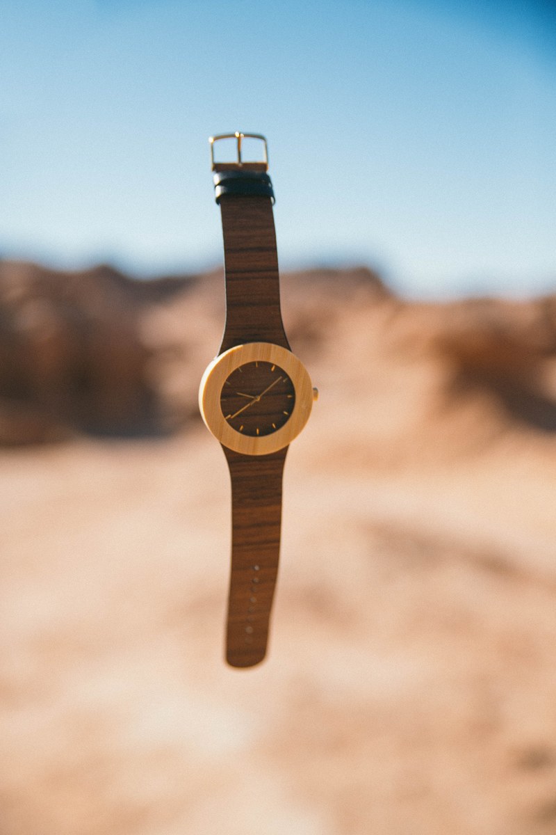 an elegant watch floating in the air above a desert, time flies 4k