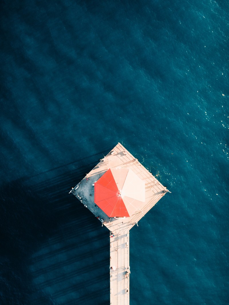 drone aerial view of the building on the pier at huntington beach, above the pier 4k