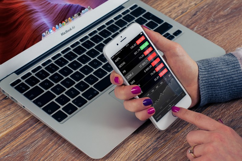 a person checking stock market prices on their iphone, checking stock market prices 4k