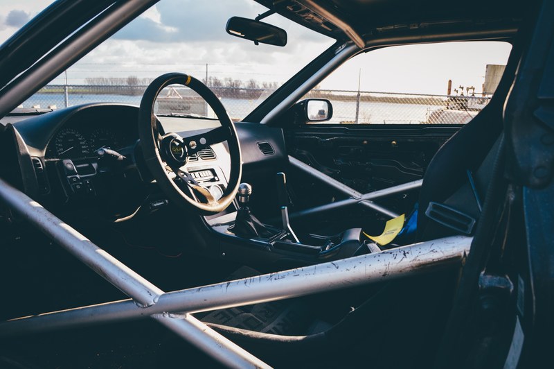 interior of race car with reinforced door and steering wheel, race car roll cage 4k