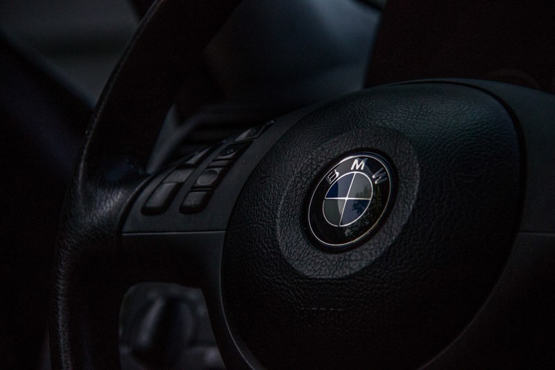 macro vew of a black bmw steering wheel, bmw steering wheel 4k