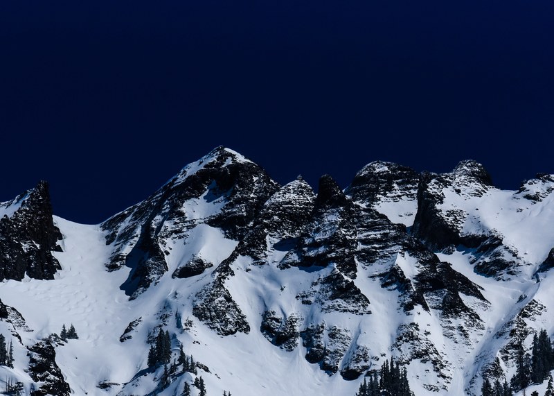 a snowy mountains crest against a dark sky in ouray, mountain crest at night 4k