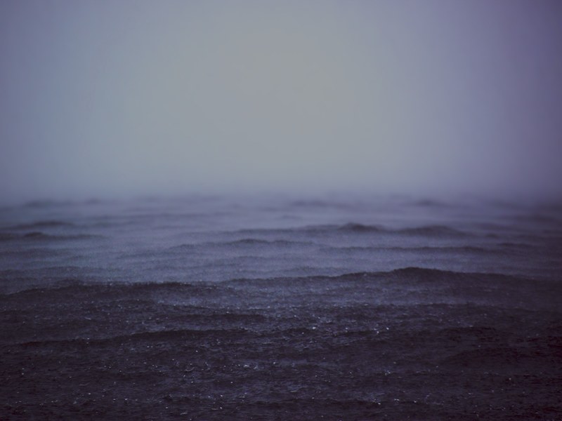 rain falls into dark stormy waters, drop in the ocean 4k