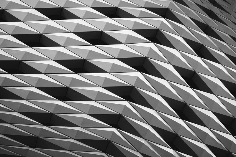 a building facade with a pattern made of black and white diamond shapes on, ginza place 4k