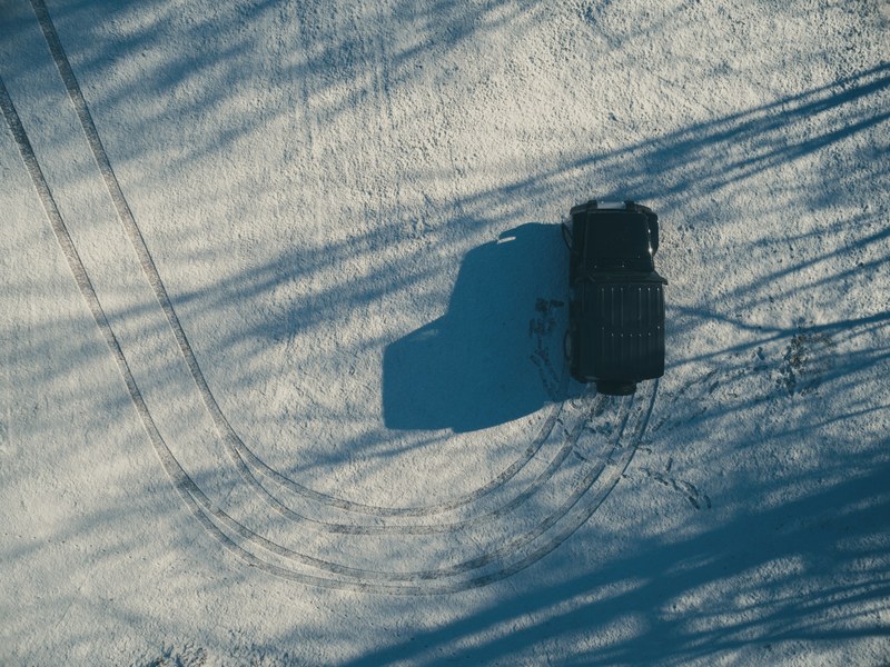 aerial view of jeep making turn on icy road, jeep driving on snow 4k