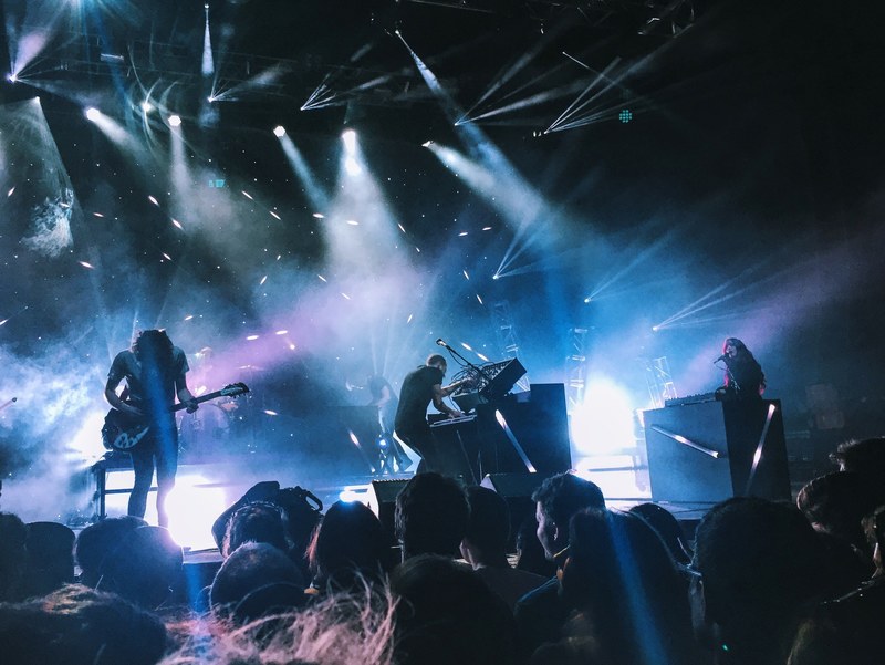 a band performing under bright spotlights in front of a young audience, rock concert in merriweather post pavilion 4k
