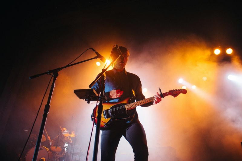 a man with a guitar singing into the microphone with spotlights illuminating the smoke behind him, death cab for cutie sydney aus 2015 4k