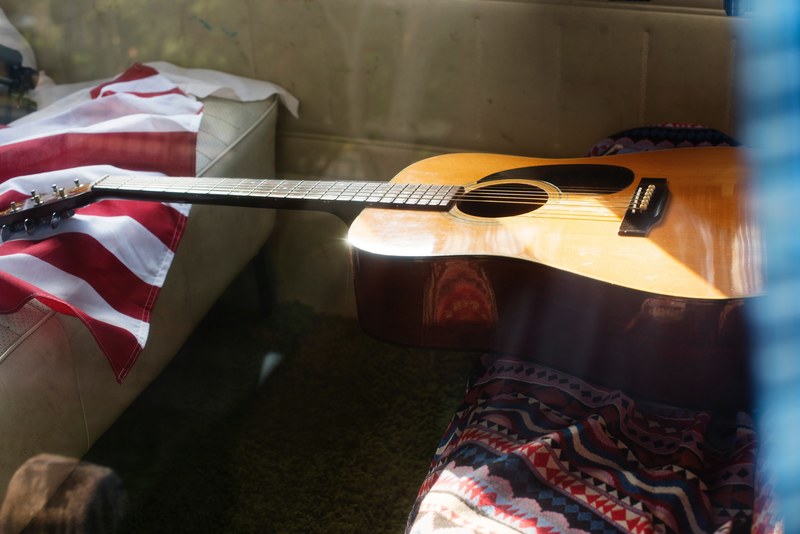 acoustic guitar and american flag in the backseat of a musicians car, musicians car 4k