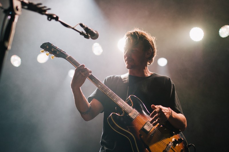 a guitar player thoughtfully strumming his electric guitar during a performance, ben howard sydney aus 2015 4k