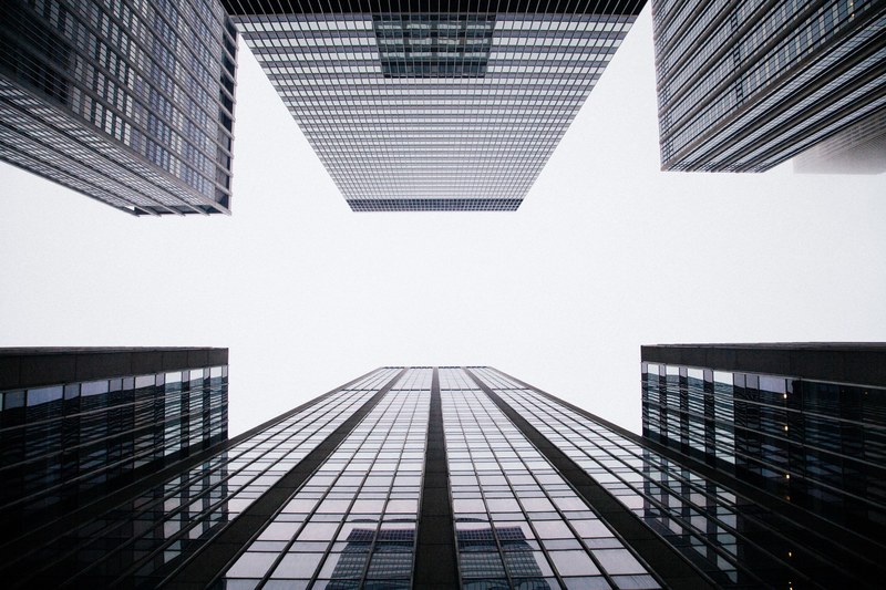 a low angle shot of tall office buildings on a cloudy day, office buildings under clouds 4k