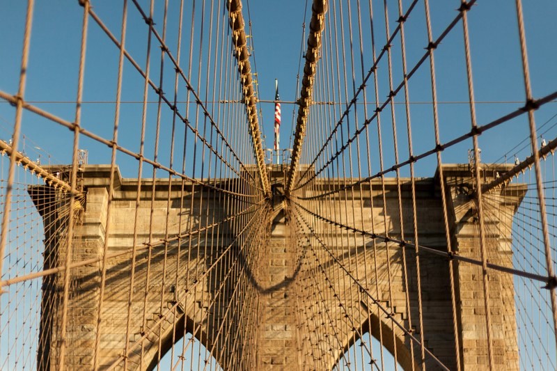american flag on top of a tower in the brooklyn bridge seen through bridge wires, brooklyn bridge tower 4k