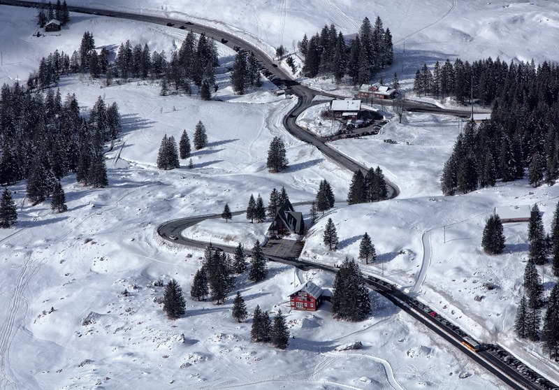winding road in the winter with snow and green pine trees and a cabin with snow on the roof, red dots 4k