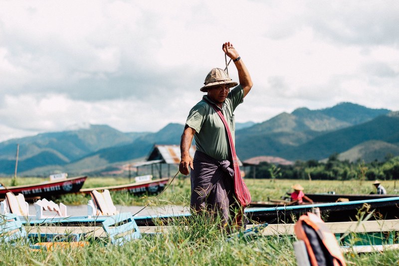 a fisherman wearing a hat preparing his fishing boat in inle lake, fishing in myanmar 4k
