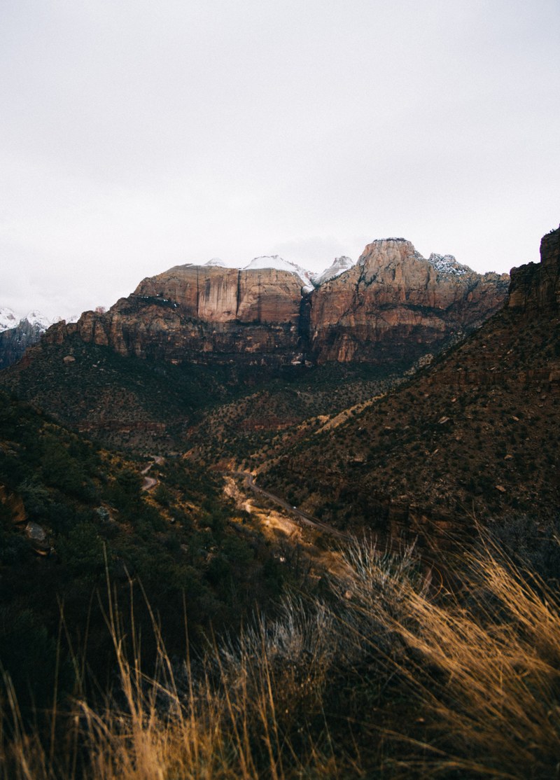 view from a mountain valley on a steep red rock face in zion national park, the road through zion 4k