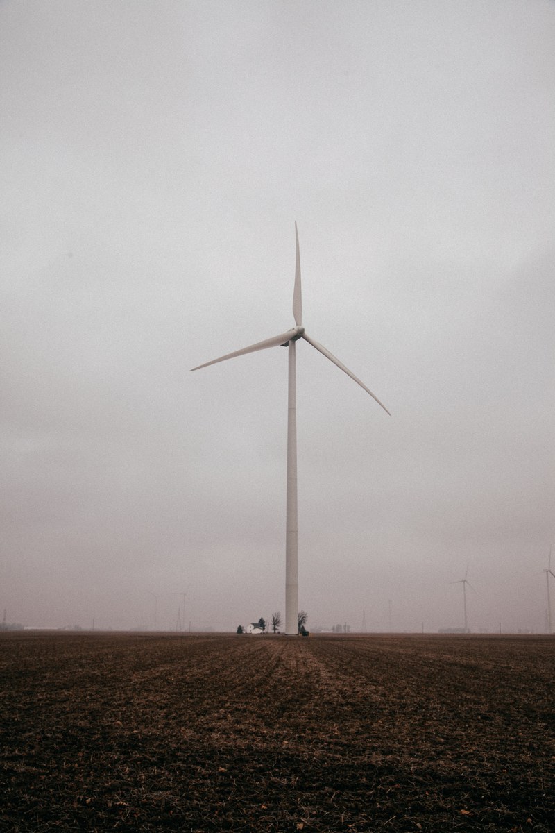single wind turbine in a farm field on a cloudy day, windmill in a farm field 4k