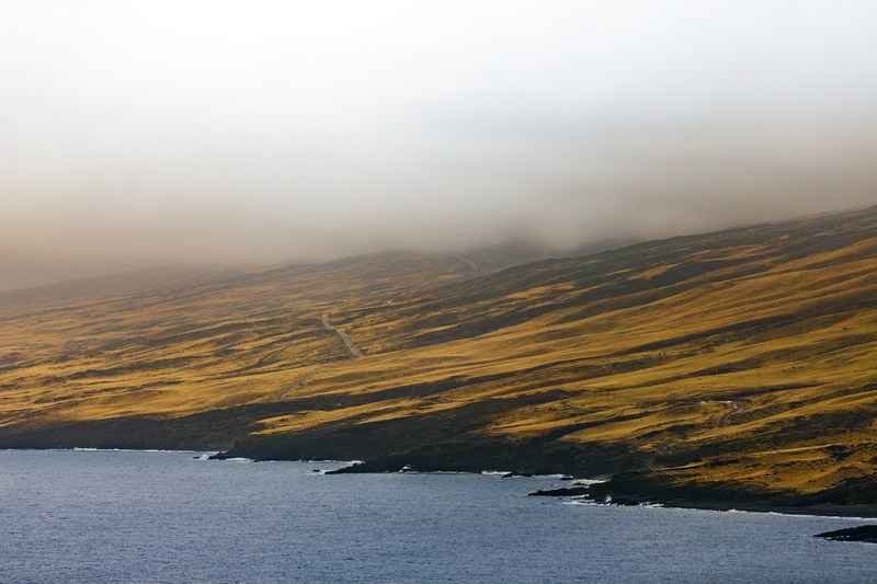 drone view of a grassy mountainside along the coast in maui, maui mountains 4k