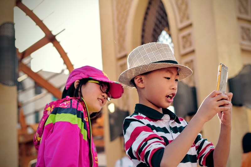 two asian children take a selfie on an iphone cellphone, selfie 4k