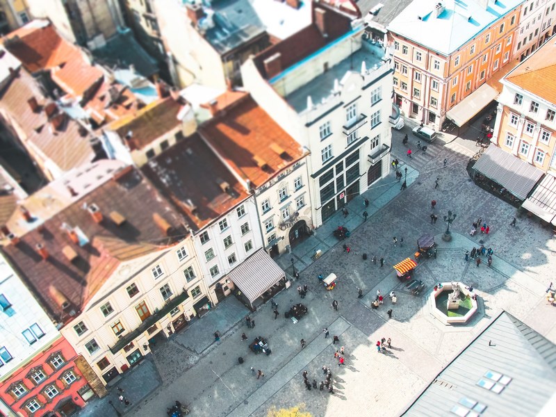 tilt shift aerial shot of busy courtyard and colorful buildings in rynok square, tiny urban ukraine 4k