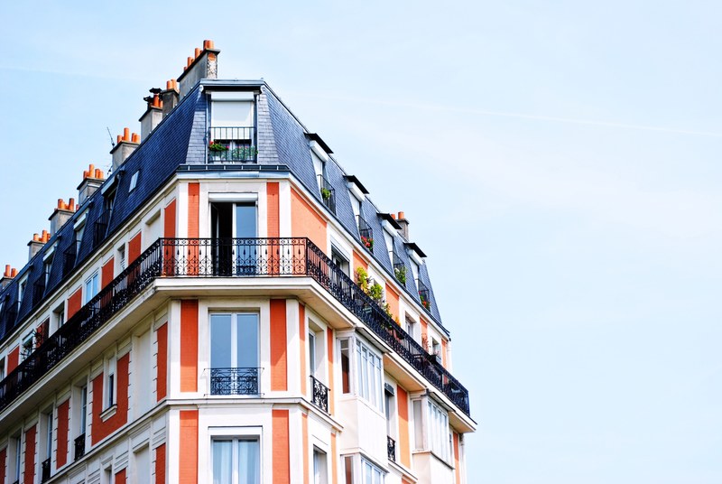 a bright colorful shot of the corner of a blue and orange building in paris, colorful building corner 4k