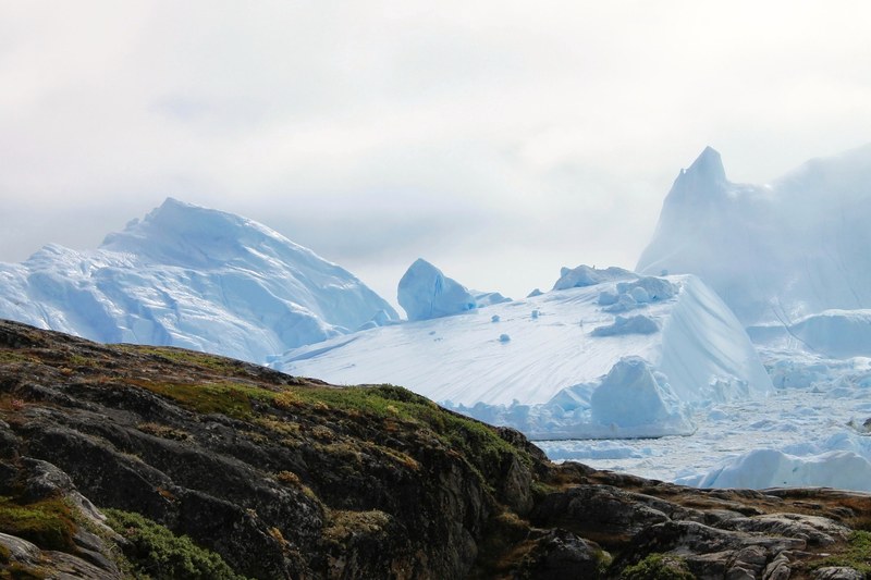 a rocky ridge against the icy glaciers of ilulissat greenland, rocky ridge and glaciers in ilulissat 4k