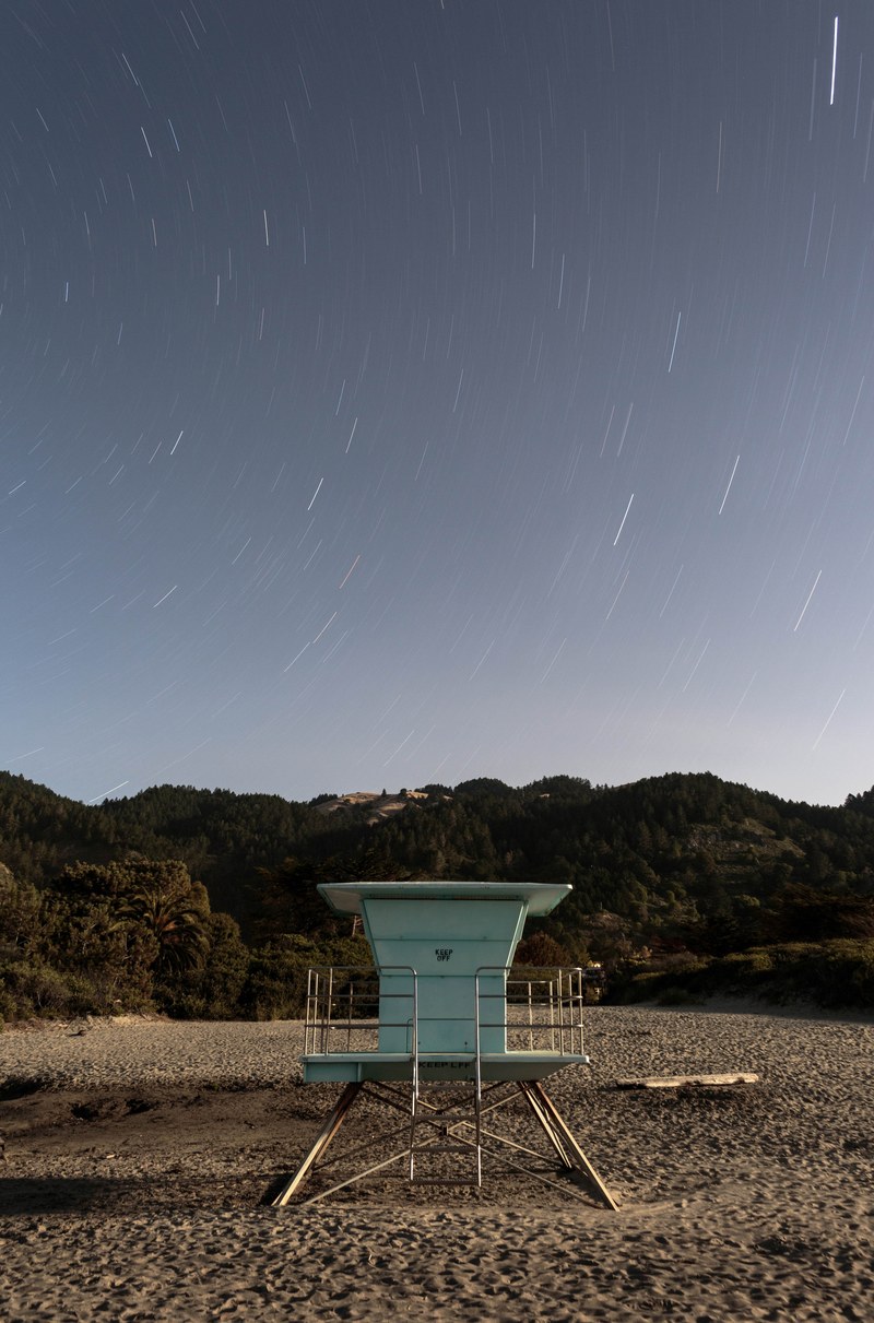 long exposure photo of starry sky over a lifeguard station on the stinson beach, lifeguard watchtower and sky 4k