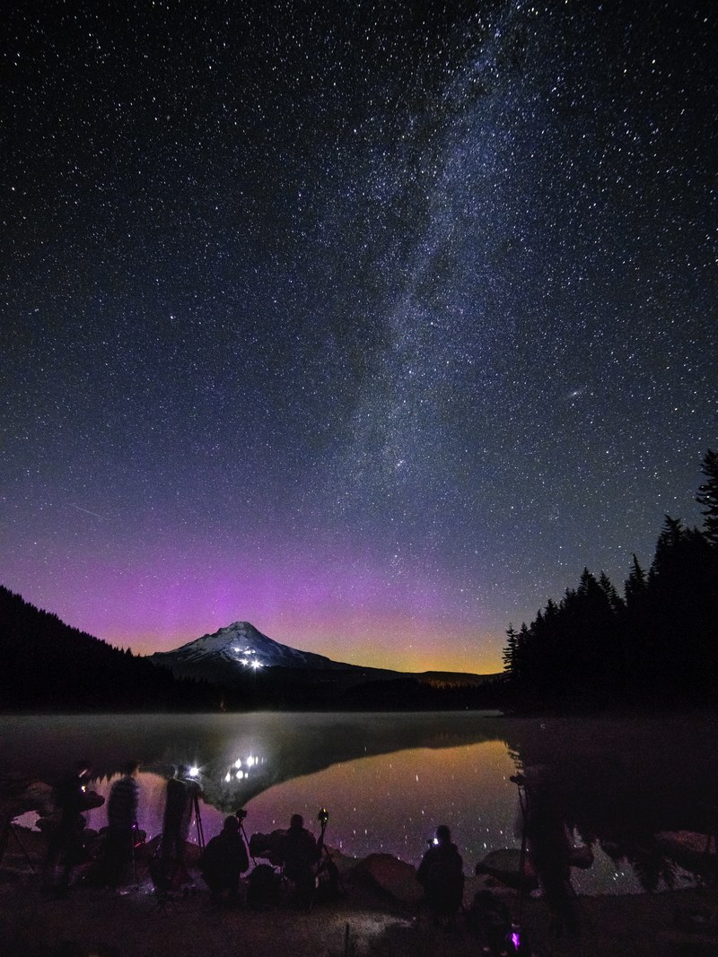 long exposure shot of people filming near trillium lake dam under a starry purple sky, a little northern lights crew 4k