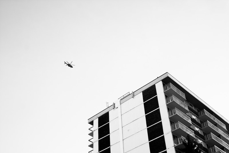 a helicopter is flying above an apartment building, _helicopter above 4k