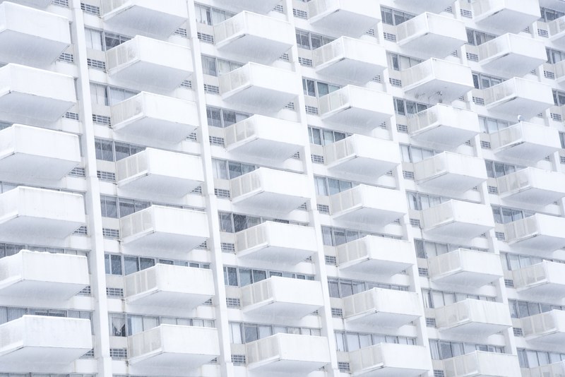 a stern white building facade with identical balconies, stern white balconies 4k