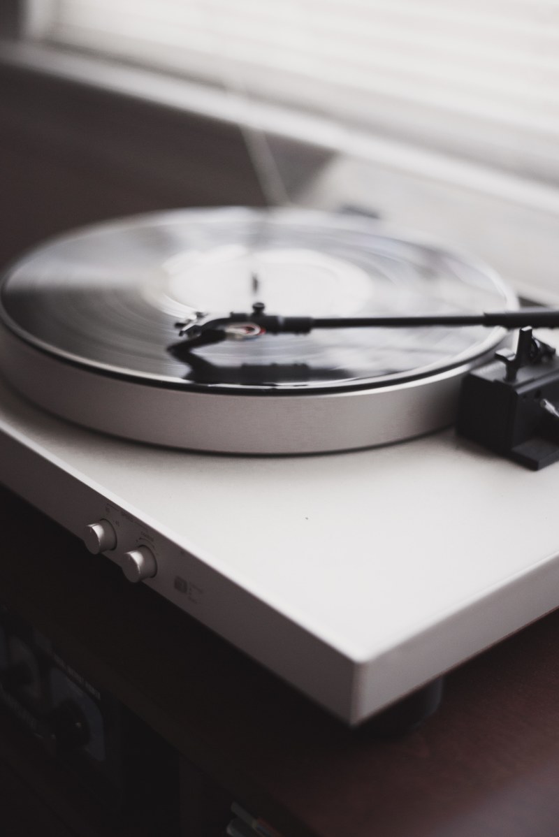 a blurry shot of a white record player playing a vinyl, white turntable playing music 4k