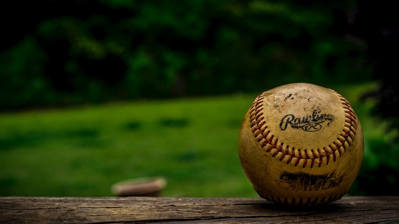 the macro view of an old baseball on a wood surface, macro view of baseball 4k