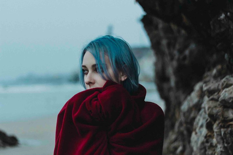 woman with blue hair and a red coat posing by the rocks at pismo beach, pismo beach ca 4k