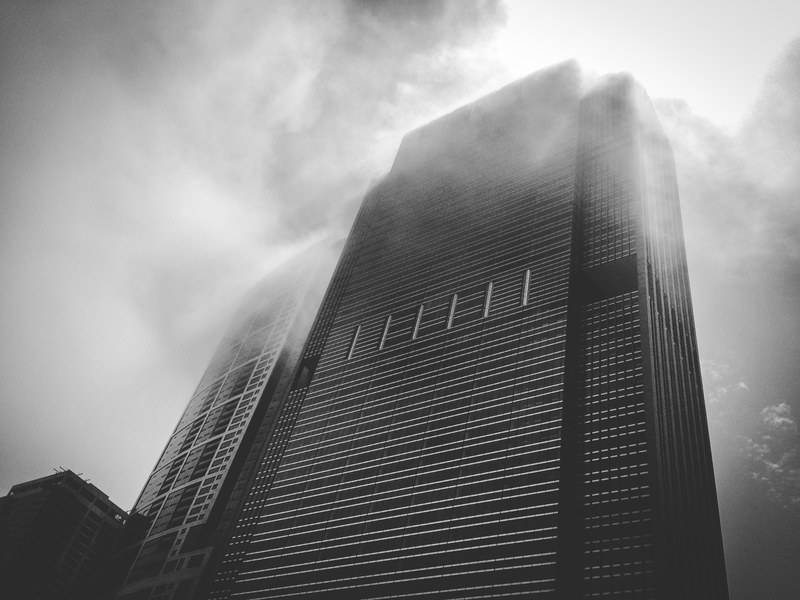 a black skyscraper shrouded in mist on a cloudy day, ominous skyscraper 4k