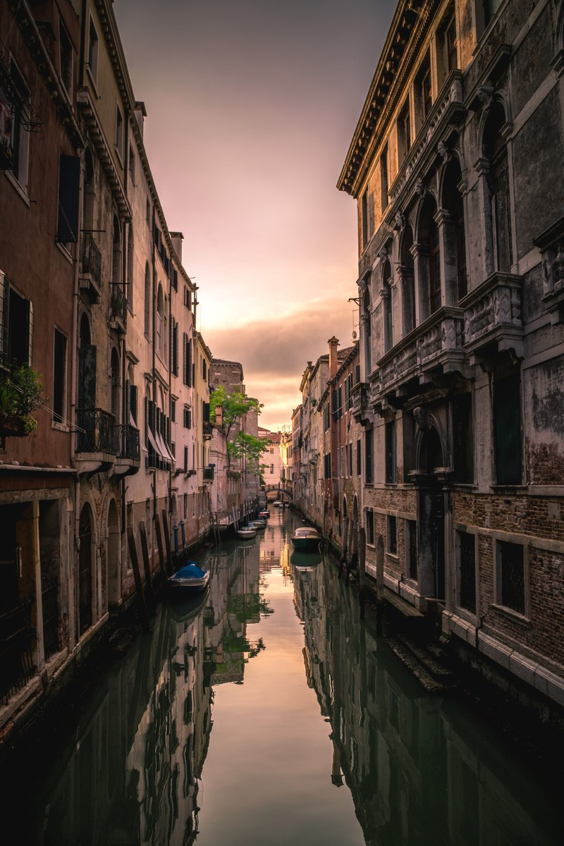 buildings reflected in the still surface of the water in a tranquil venice canal, quiet canal in venice 4k