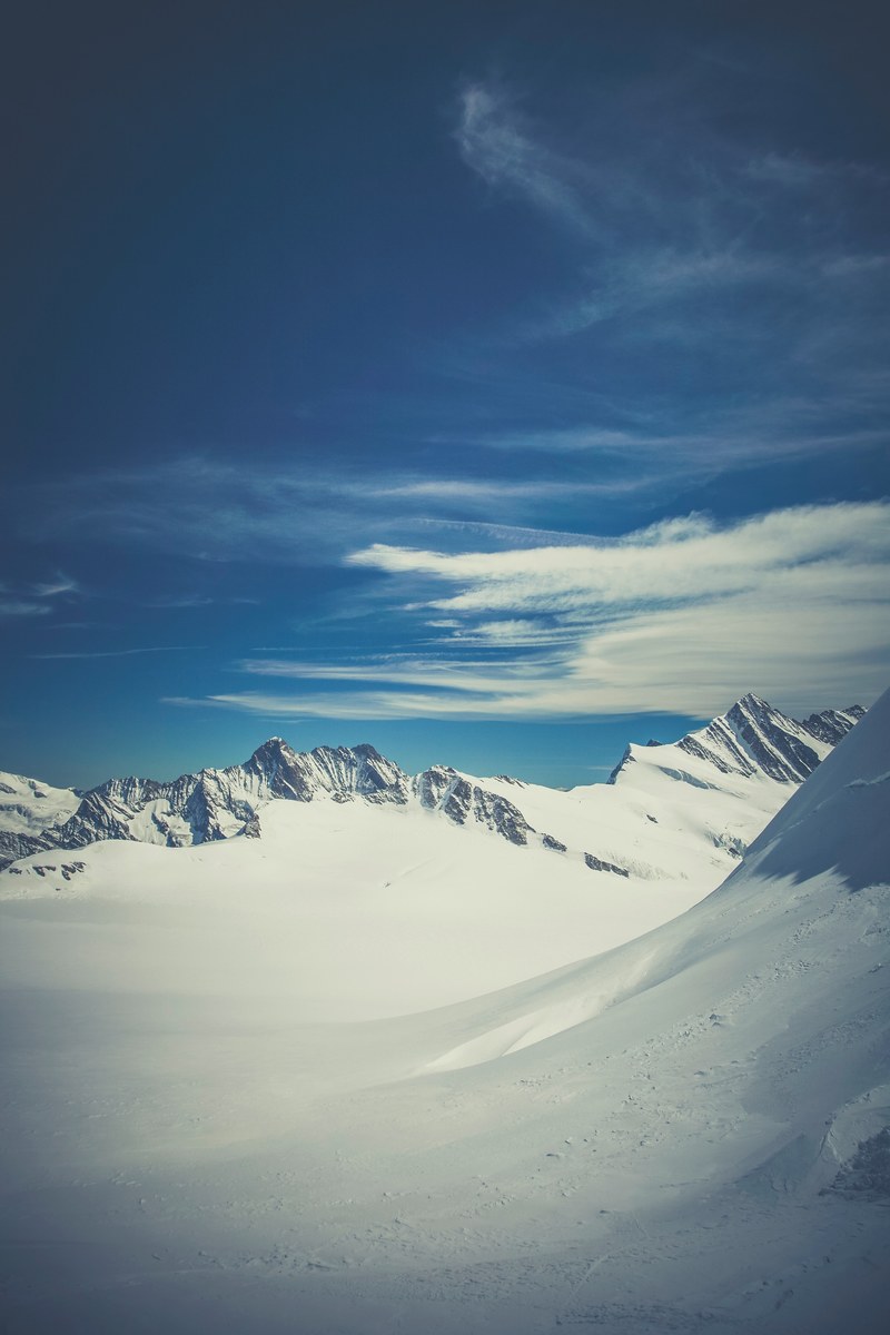 snowcapped mountains in ewigschneefld where the peak almost reaches the clouds, snowy swiss mountainscape 4k