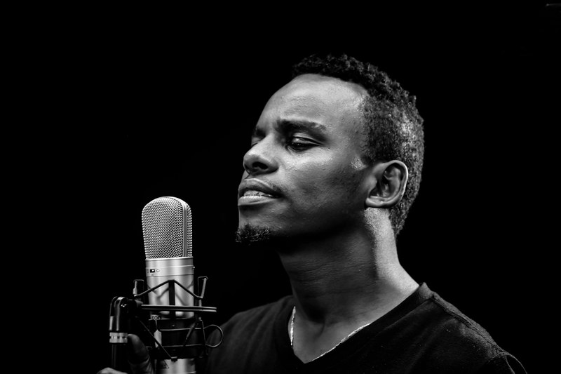 an african american man making a youtube video using a microphone, _interior fantasy 4k