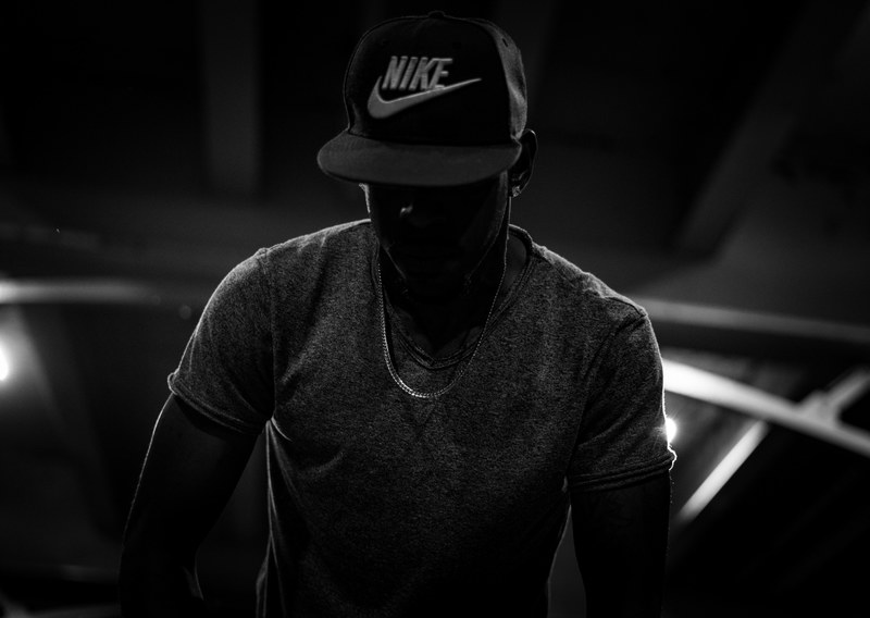 a dark man wearing a nike hat with a blackened background, _man wearing nike hat 4k