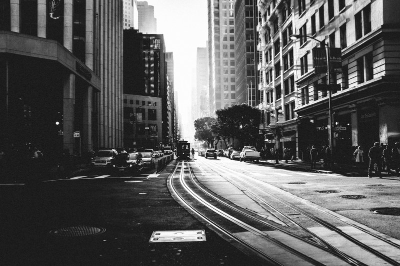 black and white shot of urban street in san francisco with people tramlines and cars, tramlines street in san fran 4k