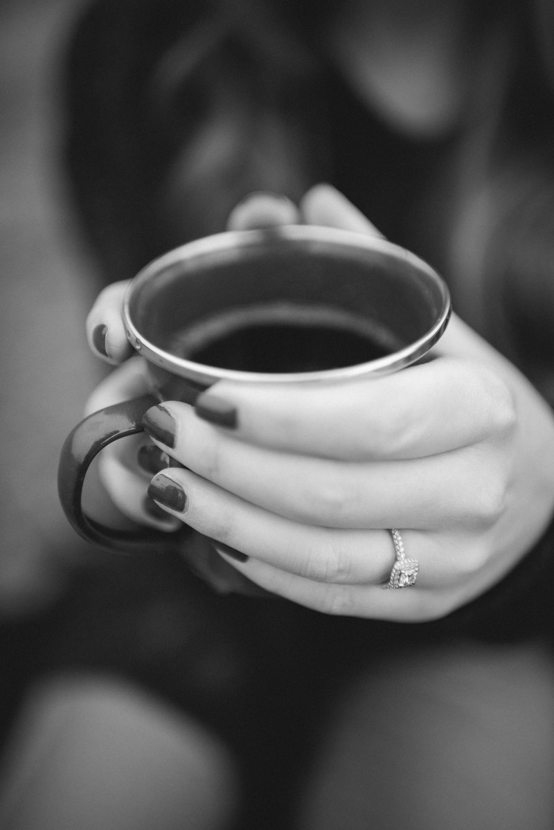 a black and white shot of a woman holding a cup of coffee, woman with hot coffee 4k