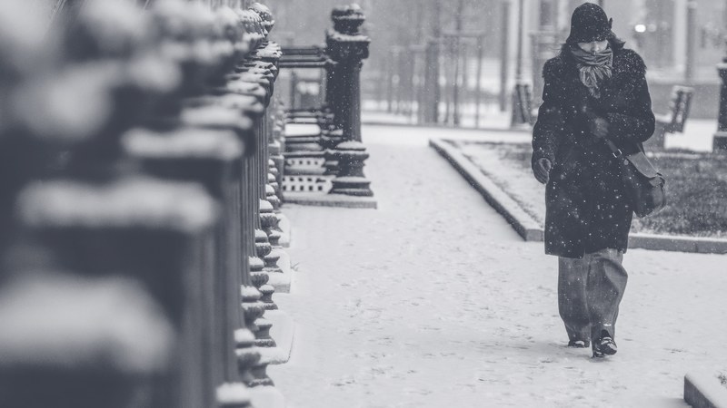 a woman walking the street in budapest on a snowy day, budapest in the snow 4k