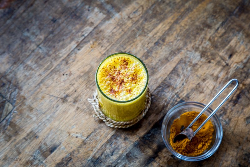 the top macro view of yellow cinnamon and an orange juice in a glass cup, cinnamon and an orange juice 4k