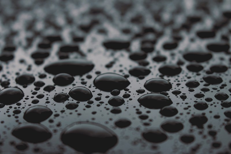 macro view of drops of rain water on a wet glass reflecting light in 996e marlin st, dark rain 4k